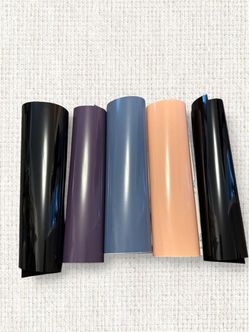 5 rolls of vinyl in black, purple, blue, pink, and black